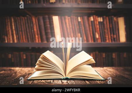 Buch auf Holztisch in Bibliothek öffnen Stockfoto