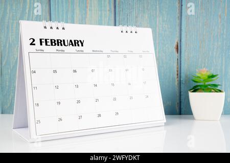 Februar 2024 Kalender auf dem weißen Tisch mit blauem Holzhintergrund. Stockfoto