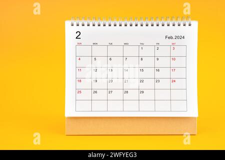 Februar 2024, monatlicher Schreibtischkalender für 2024 Jahre auf gelbem Hintergrund. Stockfoto