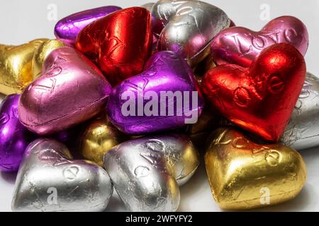 Bunte herzförmige Pralinen auf weißem Hintergrund. Nahaufnahme. St. Valentinstag-Konzept. Stockfoto