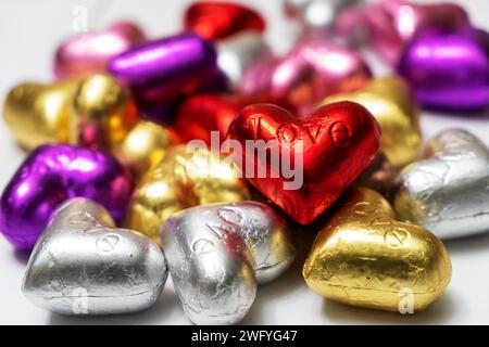 Bunte herzförmige Pralinen auf weißem Hintergrund. Nahaufnahme. St. Valentinstag-Konzept. Stockfoto