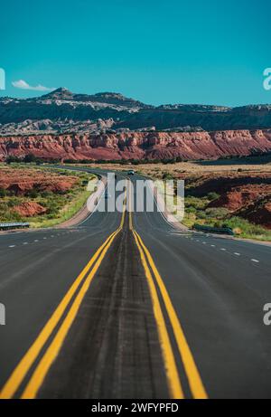 Classic panorama Blick auf eine endlose gerade Straße durch die karge Landschaft des amerikanischen Südwestens läuft Stockfoto