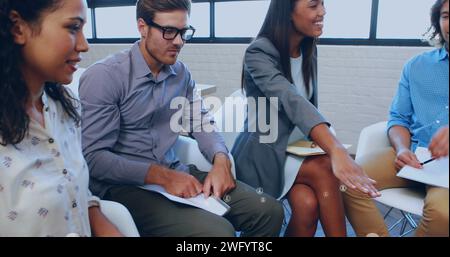 Bild eines Netzwerks von Symbolen über verschiedene Geschäftsleute im Büro Stockfoto