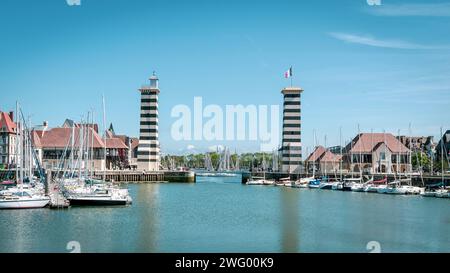 Einige Boote legten in einem lebhaften Hafen unter den Türmen an Stockfoto