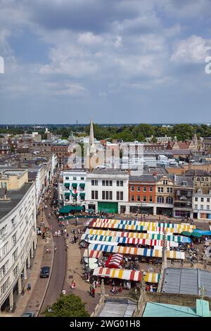 Cambridge, Großbritannien - 26. Juni 2010: Blick auf den Market Hill mit den gestreiften Einkaufszelten von der Kirche St. Mary the Great. Cambridge. E Stockfoto