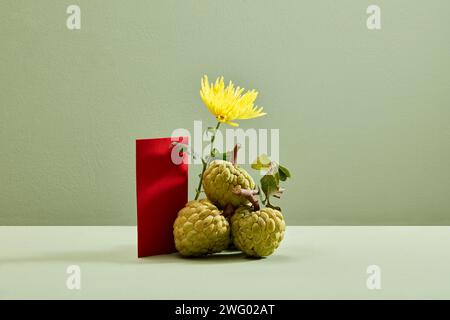 Vanilleäpfel mit einer gelben Blume und roten Umschlägen auf hellem Hintergrund. Tet-Urlaubskonzept Stockfoto