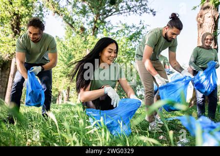 Multiethnische Gruppe von Freiwilligen mit Müllsäcken, die den Stadtpark reinigen. Stockfoto