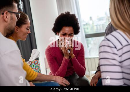 Verschiedene Gruppen von Personen, die in Gruppentherapiesitzungen im Kreis sitzen. Stockfoto