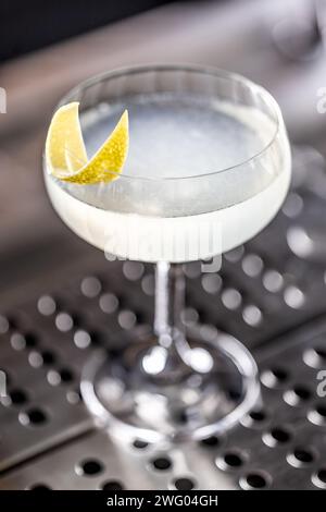 Erfrischender französischer Cocktail 75, dekoriert mit Zitronenschalen in einem Glas an der Bar. Stockfoto