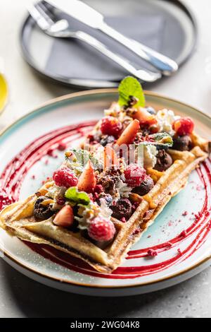 Hausgemachte Waffeln mit Erdbeeren, Himbeeren und Schlagsahne. Stockfoto