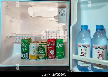 Trad, Thailand - 24. Januar 2024 - kalte Flaschen mit Wasser und Limonade stapeln sich in einer kleinen Kühlschranktür und im Hauptteil Stockfoto