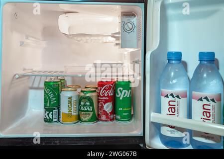 Trad, Thailand - 24. Januar 2024 - kalte Flaschen mit Wasser und Limonade stapeln sich in einer kleinen Kühlschranktür und im Hauptteil Stockfoto