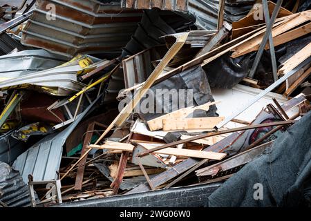 Nahaufnahme eines überfüllten Haufens von Schrott, gebrochenen Holzdielen und Kunststoffen. Der Schutt wird aufgehäuft und um einen Abbruchort verstreut. Metap Stockfoto