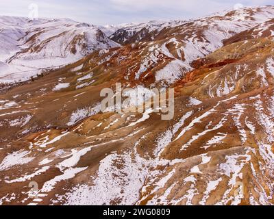 Atemberaubende Luftaufnahme von Kyzyl-Chin, bekannt als Mars, mit lebendigen Bergen und verschneiten Flecken in Altai, Russland. Stockfoto