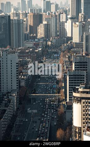 Auf den Hauptstraßen von Wuhan fahren viele Fahrzeuge dicht. Sonnenlicht scheint auf die Straßenoberfläche Stockfoto