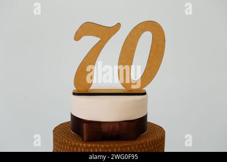 Detail der Zahl siebzig oben auf dem Geburtstagskuchen, 70 Geburtstag, weißer Kuchen, 70 Jahre alte Geburtstagskuchen Kerze Stockfoto