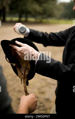 Eine weibliche Fussel rollt ihren Reithelm vor einer traditionellen Fuchsjagd. Stockfoto