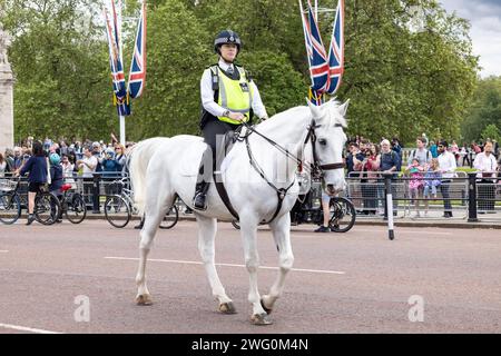 London, UK - 21. Mai 2023: Eine unidentifizierte Londoner Polizistin, die auf einem weißen Pferd reitet, ist während des Wachwechsels bei Buckingham PAL im Dienst Stockfoto