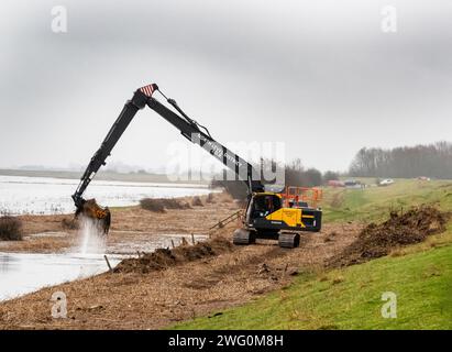 Eine Maschine, die Flutschutt aus einem Entwässerungsgraben auf den Nene-Waschanlagen in Cambridgeshire, Großbritannien, entfernt. Stockfoto