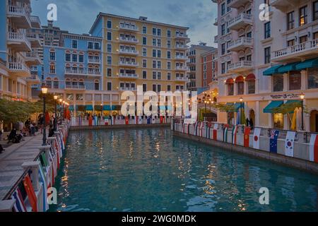 Qanat Quartier in der Perle, Doha Qatar Sonnenuntergang Schuss während des AFC Asian Cup 2023 mit Fahnen der teilnehmenden Teams, einzigartige Architektur von Gebäuden Stockfoto