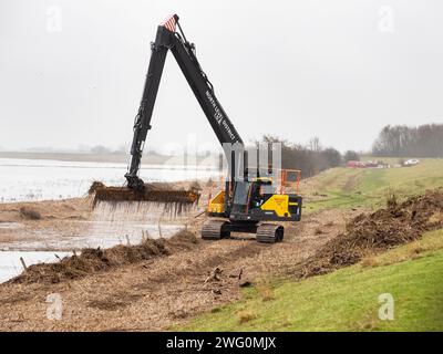 Eine Maschine, die Flutschutt aus einem Entwässerungsgraben auf den Nene-Waschanlagen in Cambridgeshire, Großbritannien, entfernt. Stockfoto