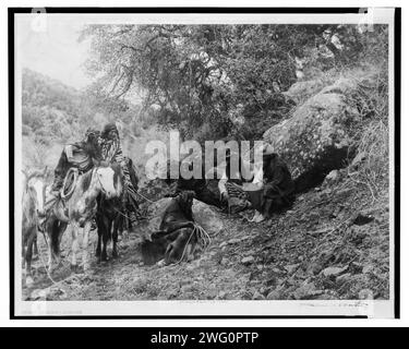 Geschichtenerzählen, 1906. Eine Gruppe von Apachen-Männern, zwei zu Pferd, andere sitzen, zuhören und zuschauen, während ein Mitglied der Partei den Boden mit einem Stock markiert. Stockfoto