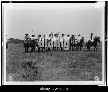 Chiefs in the Sun Dance Parade - Cheyenne, 1927. Mehrere Cheyenne-Häuptlinge zu Pferd in einer Reihe auf einem offenen Feld. Stockfoto