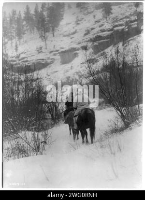 Winterjäger[s]-Apsaroke, 1908. Zwei Apsaroke-Männer reiten auf einem schneebedeckten Hügel. Stockfoto