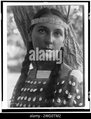 Lucille, 1907. Kopf-und-Schultern-Porträt einer Dakota-Frau, die vor einem Baum steht. Stockfoto