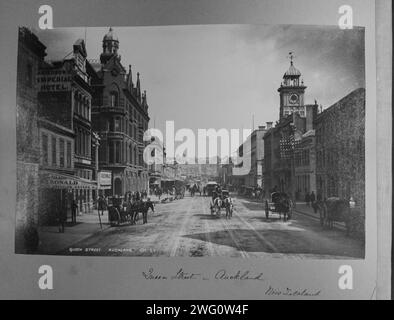 S&W-Adaption von Queen Street - Aucklan New Zealand. Blick auf die Queen Street in Auckland. Drei- und vierstöckige neogotische Gebäude säumen die Straße auf beiden Seiten. Viele Fußgänger und Pferdekutschen sichtbar. Von Charles Appleton Longfellow's Reise nach Neuseeland im Jahr 1891. Stockfoto