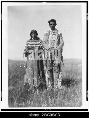 Joe Russell, 1910. Piegan-Mann und -Frau stehen in offener Prärie. Stockfoto