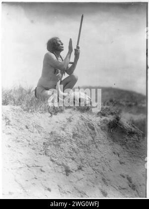 Gebet an das große Geheimnis, (Slow Bulle), 1907. Slow Bull, hockend, mit Hosentuch, mit Pfeife und Mundstück nach oben gerichtet, Büffelschädel zu seinen Füßen. Stockfoto