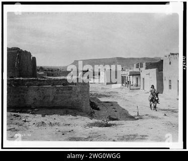 Eine Straßenszene in San Ildefonso Pueblo, 1905, 1905. San Ildefonso, New Mexico, zeigt Straßen und lehmziegelhäuser und einen Jungen, der auf einem Burro reitet. Stockfoto