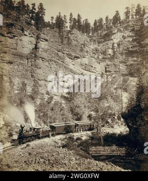 Riesen Bluff Elk Canyon auf Black Hills und ft P RR, 1890. Ein zweiteiliger Zug vor einer steilen Klippe; mehrere Passagiere posieren vor dem Zug. Stockfoto