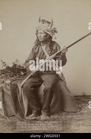 Little, der Anstifter der indischen Revolte in Pine Ridge, 1890, 1891. Little, Oglala Bandleader, Studio-Porträt in voller Länge, sitzend, nach links gerichtet, mit Hornkopf und Haltegewehr. Stockfoto