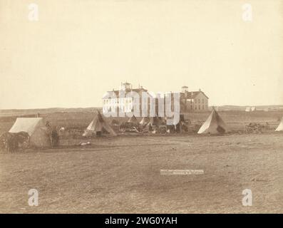 US-Schule für Indianer in Pine Ridge, SD, 1891. Kleines Tipi-Camp in Oglala vor großen Regierungsschulgebäuden auf freiem Feld. Stockfoto