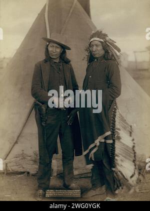 Red Cloud und American Horse, die beiden bekanntesten Häuptlinge, die jetzt leben, 1891. Zwei Oglala-Häuptlinge, American Horse (mit Westernkleidung und Pistole in Holster) und Red Cloud (mit Kopfschmuck), Porträt in voller Länge, nach vorne gerichtet, Hände schütteln vor dem Tipi, wahrscheinlich auf oder in der Nähe des Pine Ridge Reservation. Stockfoto