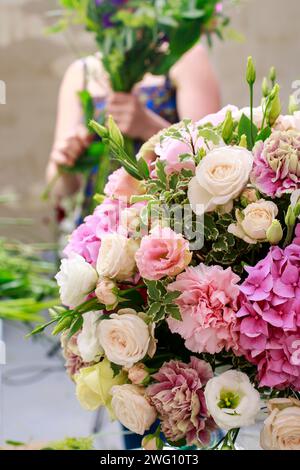 Blumengeschäft am Arbeitsplatz: Frau Blumenarrangement mit Nelke, Eustoma und Hortensia Blumen machen. Stockfoto