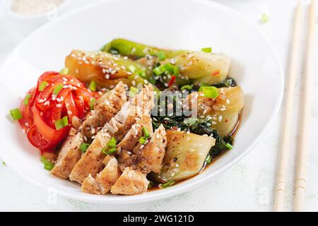 Gebratenes Hühnchen, süße Paprika und Pak Choy in einer Schüssel auf dem Tisch verrühren. Braten Sie pak Choi unter Rühren. Asiatisches Essen. Stockfoto