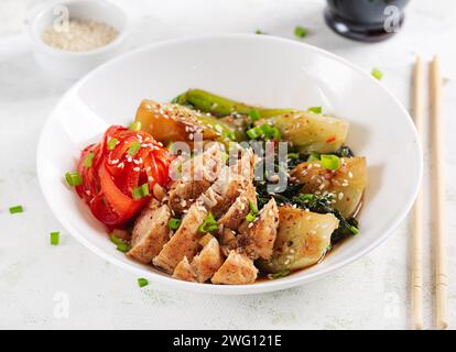 Gebratenes Hühnchen, süße Paprika und Pak Choy in einer Schüssel auf dem Tisch verrühren. Braten Sie pak Choi unter Rühren. Asiatisches Essen. Stockfoto