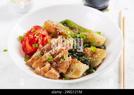 Gebratenes Hühnchen, süße Paprika und Pak Choy in einer Schüssel auf dem Tisch verrühren. Braten Sie pak Choi unter Rühren. Asiatisches Essen. Stockfoto