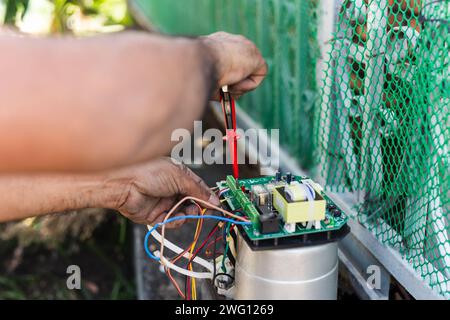 Elektriker prüfen Schalter in der elektrischen Hauptplatine von Hand. Stockfoto