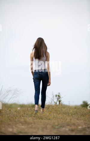 Frau aus Rücksicht, die auf dem Feld weggeht Stockfoto