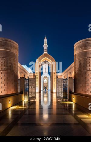Sultan Qaboos große Moschee, beleuchteter Bogengang mit Minarett, Muskat, Oman Stockfoto