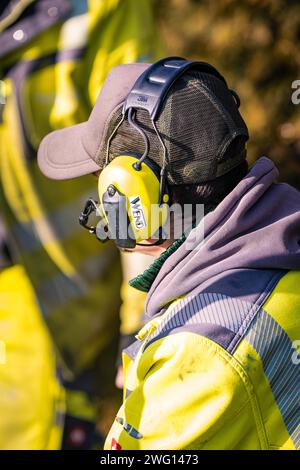 Profilansicht eines Arbeitnehmers mit Schutzhelm und Gehörschutz im Dialog, Glasfaserbau, Nagold, Schwarzwald, Deutschland Stockfoto