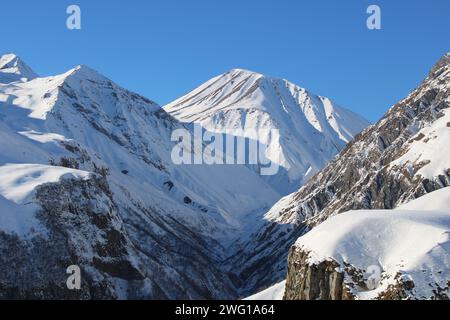Sonniger Tag in den Bergen des kaukasus. Schneegipfel und Felsen, tiefe Schlucht. Schöne Jahreszeit für Reisen in Georgia Stockfoto