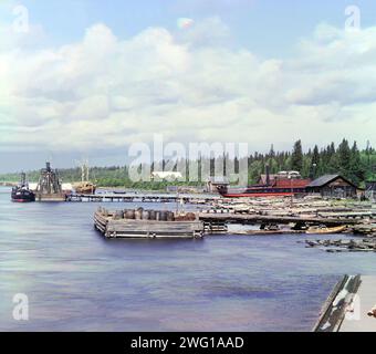 Kareshka Bootswerft [Russisches Reich], 1909. Beschriftungsschild aus der Ausstellung der digitalen Kopie in "das Reich, das Russland war" (2001) - Transport: Kareshka Boat Yards. Eine Vielzahl von Kanalbooten und Lastkähnen, groß und klein, an einem geschützten Einlass vor der Südwestküste des Onegasees am Mariinskii-Kanalsystem in der Nähe der kleinen Stadt Voznesenie im Norden Europas Russlands. Stockfoto