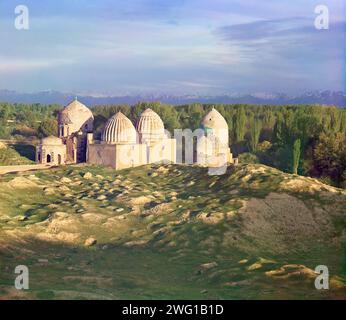 Allgemeine Ansicht der Shakh-i Zindeh Moschee, Samarkand, zwischen 1905 und 1915. Die Pamir Mountains bieten eine dramatische Kulisse für einen abendlichen Blick auf die Shakh-i Zindeh Moschee in Samarkand, ein Komplex von Gräbern und Leichenkapellen, die über viele Jahrhunderte für die Frauen der Dynastien errichtet wurden, die von Timur (Tamerlane, 1336-1405), der großen mittelalterlichen Herrscherin Zentralasiens, abstammen. Stockfoto