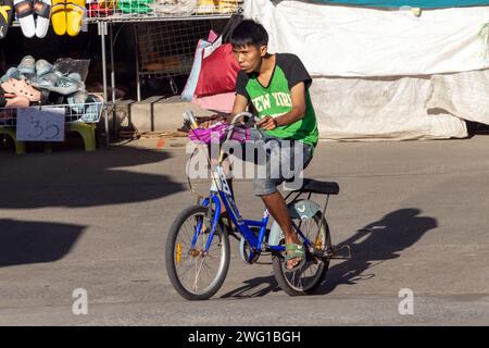 SAMUT PRAKAN, THAILAND, 07. Dezember 2023, Ein junger Radfahrer fährt durch den Markt Stockfoto