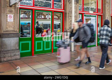 Verzerrte Reflexionen von Fahrgästen und Zügen. Lichtbrechung im Bahnhof Preston, Großbritannien Stockfoto